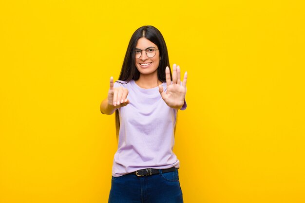 sorrindo e parecendo amigável, mostrando o número seis ou sexto com a mão para a frente, contando