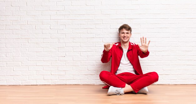 sorrindo e parecendo amigável, mostrando o número seis ou sexto com a mão para a frente, contando