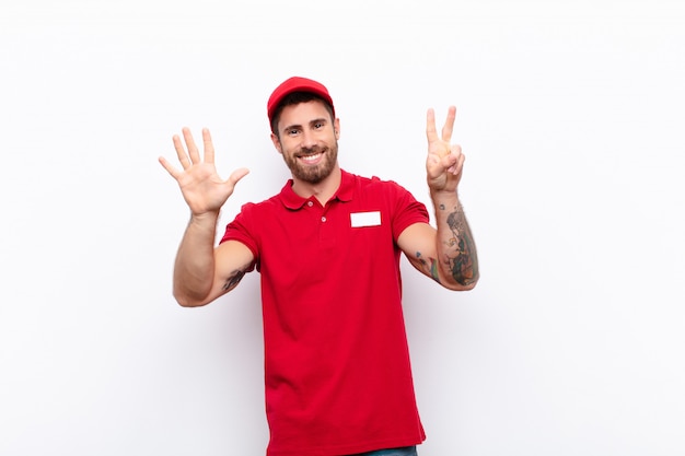 sorrindo e parecendo amigável, mostrando o número sete ou sétimo com a mão para a frente, contando