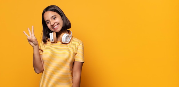 Sorrindo e parecendo amigável, mostrando o número três ou terceiro com a mão para a frente, em contagem regressiva