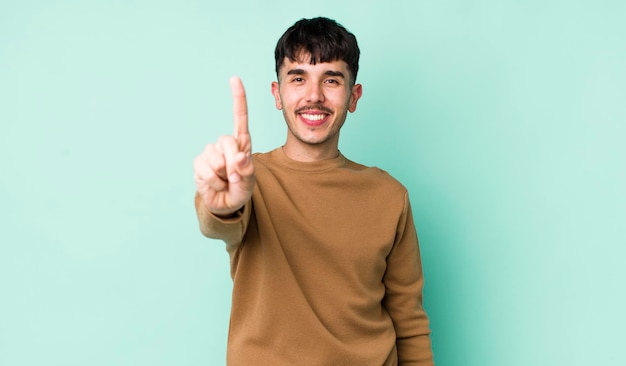 Sorrindo e parecendo amigável mostrando o número um ou o primeiro com a mão em contagem regressiva