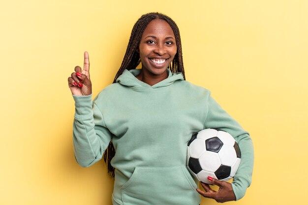 Sorrindo e parecendo amigável, mostrando o número um ou o primeiro com a mão para a frente, em contagem regressiva. conceito de futebol