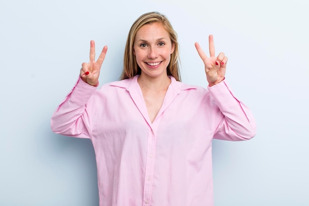 Sorrindo e parecendo feliz, amigável e satisfeito, gesticulando vitória ou paz com as duas mãos