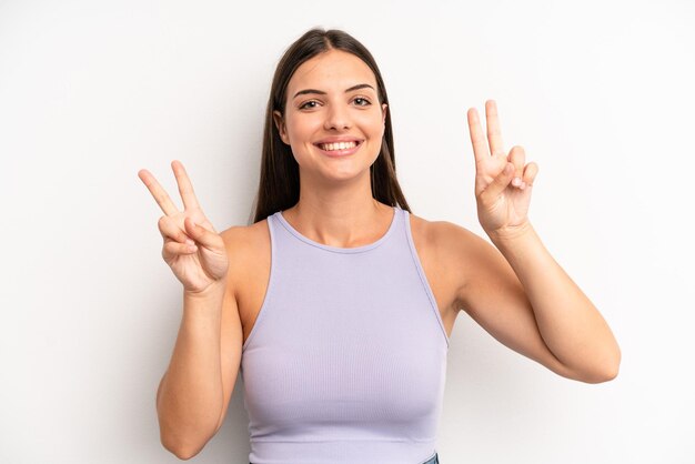 Sorrindo e parecendo feliz, amigável e satisfeito, gesticulando vitória ou paz com as duas mãos