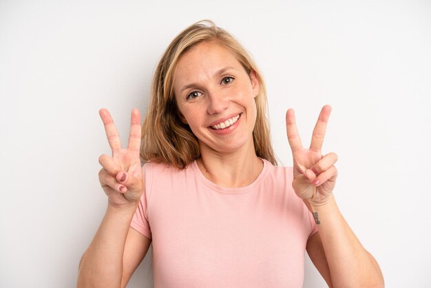 Sorrindo e parecendo feliz, amigável e satisfeito, gesticulando vitória ou paz com as duas mãos