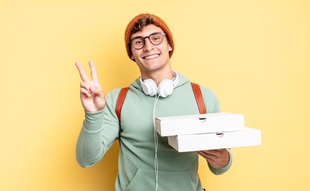 Sorrindo e parecendo feliz, despreocupado e positivo, gesticulando vitória ou paz com uma mão. conceito de pizza