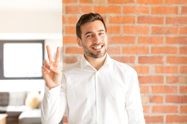 sorrindo e parecendo feliz, despreocupado e positivo, gesticulando vitória ou paz com uma mão