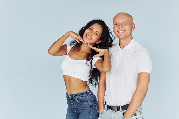 Sorrindo e posando para a câmera casal alegre está junto dentro de casa