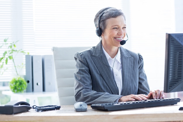 Sorrindo empresária usando computador e telefonando