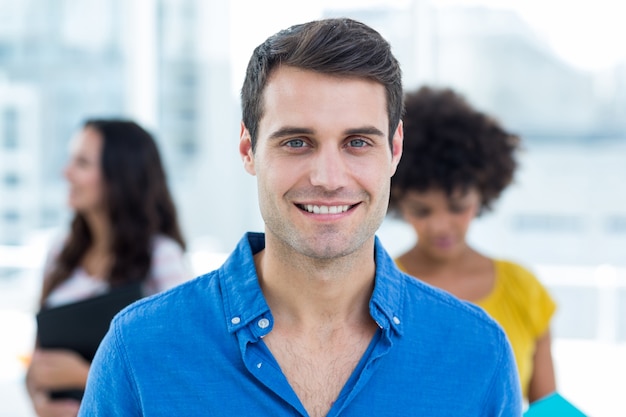 Sorrindo empresário com seus colegas atrás