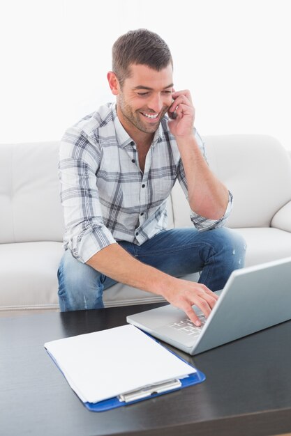 Sorrindo empresário no telefone em uma mesa