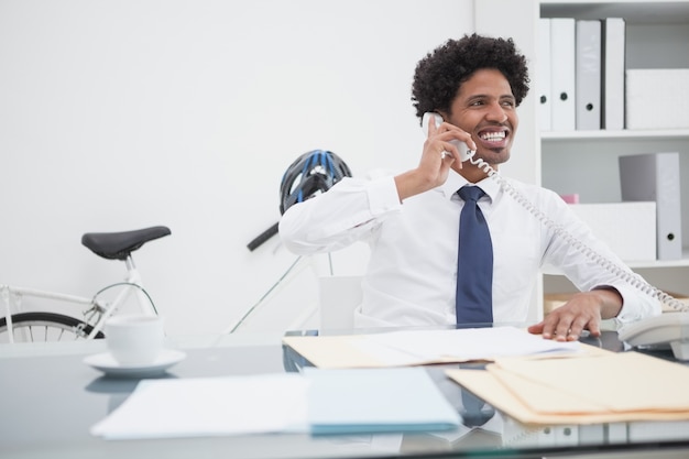 Sorrindo empresário no telefone na mesa