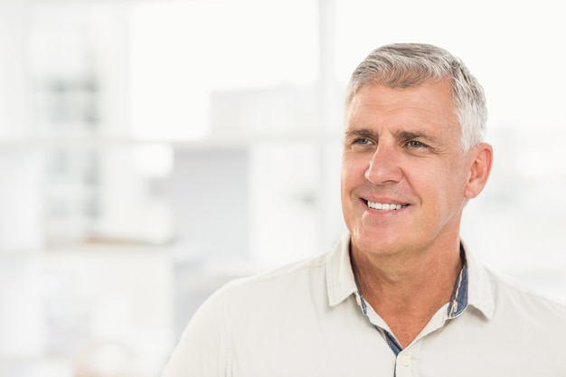 Sorrindo empresário olhando longe no escritório