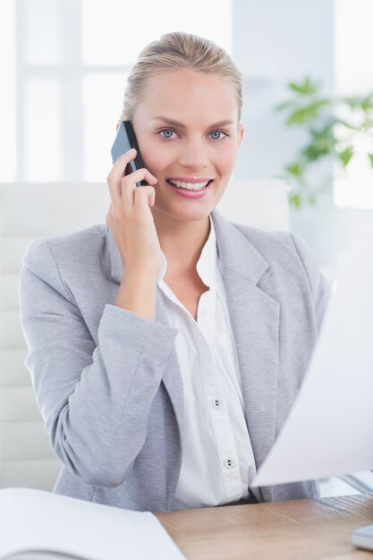 Sorrindo empresário telefonando para sua mesa