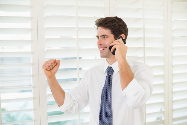 Sorrindo, empresário, usando, móvel, telefone, apertar, punho