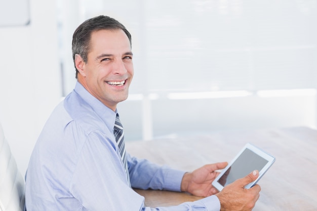 Sorrindo empresário usando tablet