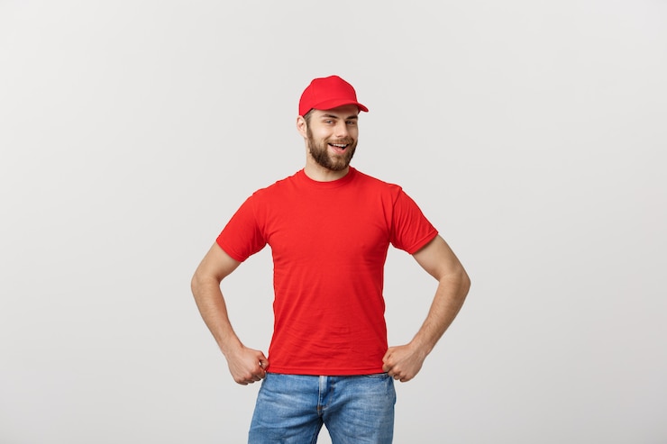 Foto sorrindo entregador de uniforme vermelho em pé com o braço cruzado