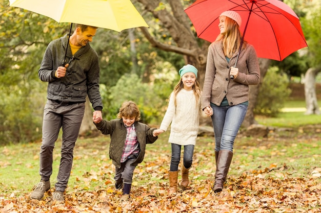 Sorrindo família jovem sob o guarda-chuva