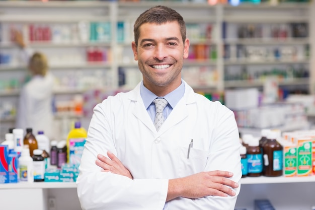 Sorrindo farmacêutico em bata de laboratório olhando câmera