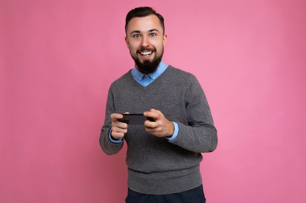 Sorrindo, feliz, bonito, bonito, morena, jovem barbudo, vestindo um suéter cinza e uma camisa azul