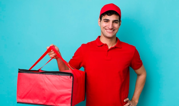 sorrindo feliz com uma mão no quadril e confiante