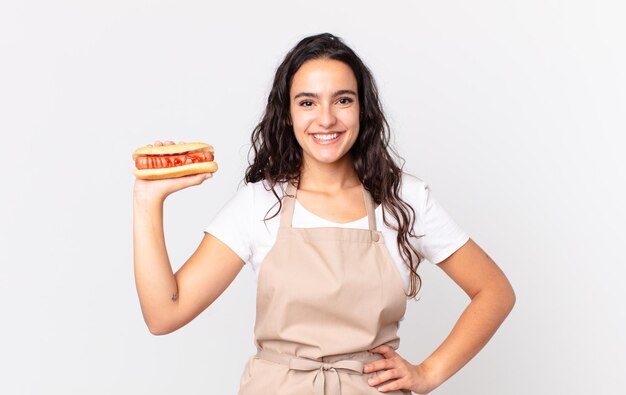 sorrindo feliz com uma mão no quadril e confiante