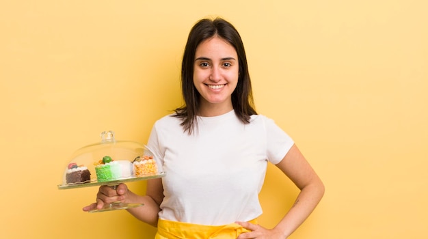 Sorrindo feliz com uma mão no quadril e confiante