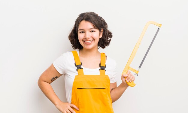 sorrindo feliz com uma mão no quadril e confiante