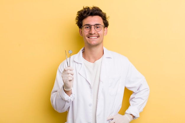 sorrindo feliz com uma mão no quadril e confiante