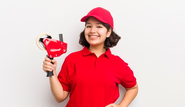 sorrindo feliz com uma mão no quadril e confiante