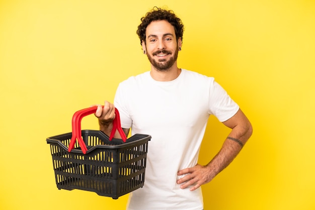 sorrindo feliz com uma mão no quadril e confiante