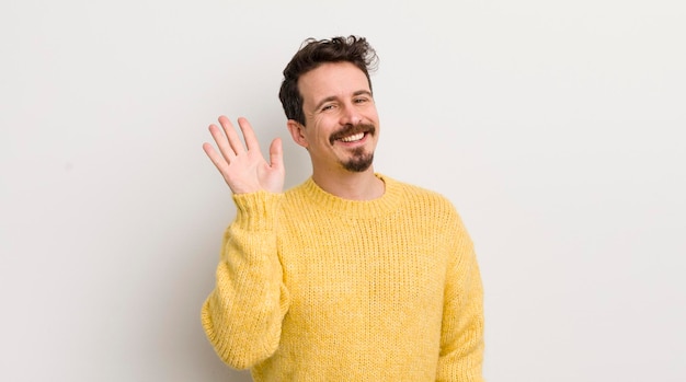 Sorrindo feliz e alegremente acenando com a mão dando as boas-vindas e cumprimentando você ou dizendo adeus