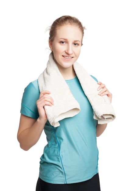 Sorrindo feliz modelo de fitness feminino com uma toalha olhando para a câmera isolada no fundo branco