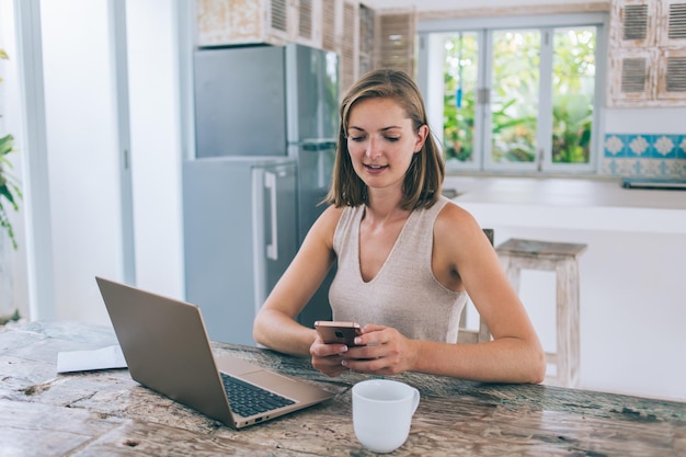 Sorrindo feminino navegando smartphone em casa