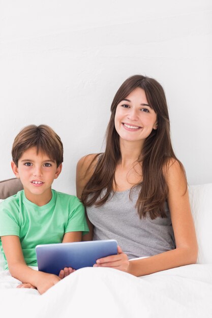 Sorrindo filho e mãe usando tablet