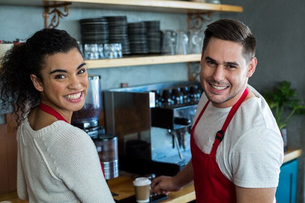 Sorrindo, garçonete e garçom no café