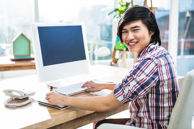 Sorrindo, hipster, homem negócios, usando computador, em, escritório