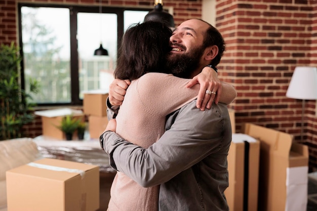 Foto sorrindo, homem e mulher se abraçando depois de morarem juntos, aproveitando o evento da vida e novos começos familiares. compartilhando abraço e abraço, usando empréstimo hipotecário para comprar o primeiro espaço de apartamento para o futuro.