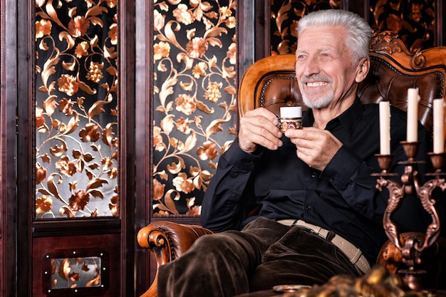 Sorrindo homem sênior bebendo café