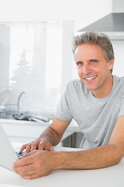 Sorrindo, homem, usando, laptop, cozinha