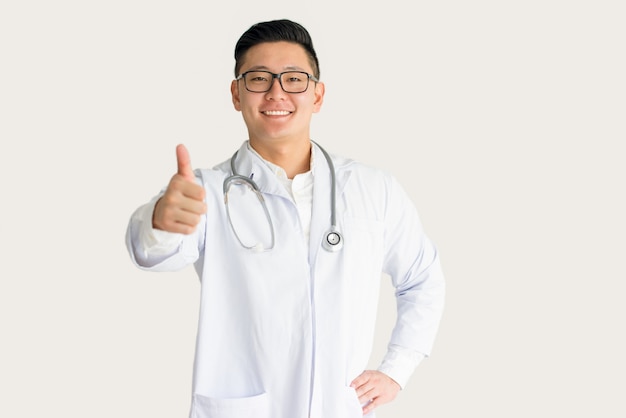 Sorrindo, jovem, asiático, doutor, mostrando, polegar cima