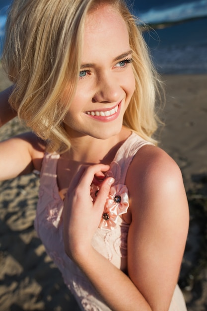 Sorrindo jovem e relaxante olhando para longe na praia