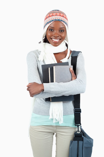 Sorrindo jovem estudante em roupas de inverno com seus livros