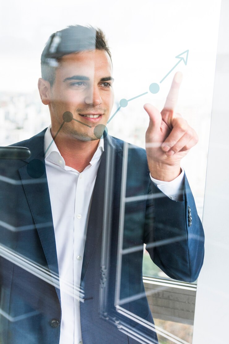 Foto sorrindo, jovem, homem negócios, apontar dedo, em, aumentando, gráfico, ligado, vidro transparente