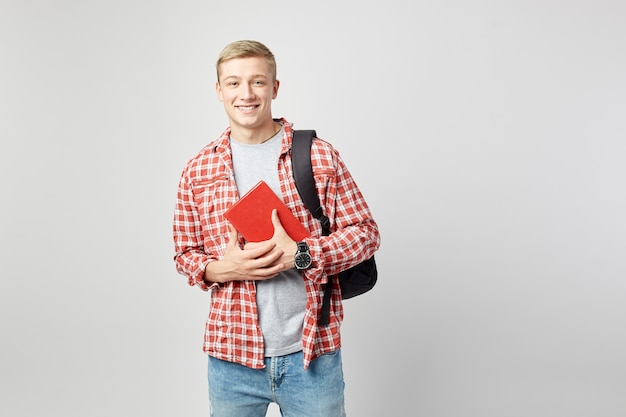 sorrindo jovem loiro com mochila segurando livros nas mãos