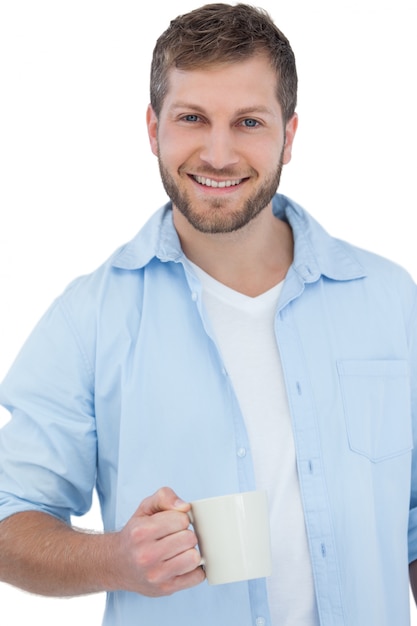 Sorrindo jovem modelo segurando uma caneca