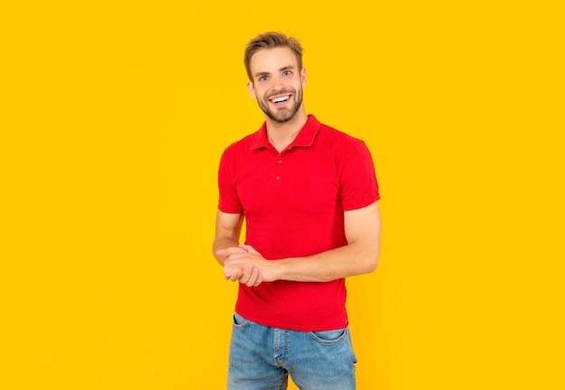 Sorrindo jovem não barbeado na camisa vermelha na moda de fundo amarelo