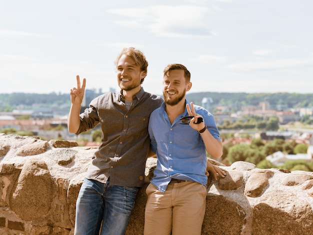 Sorrindo jovens amigos caucasianos na frente do horizonte da cidade como conceito de viagem e amizade