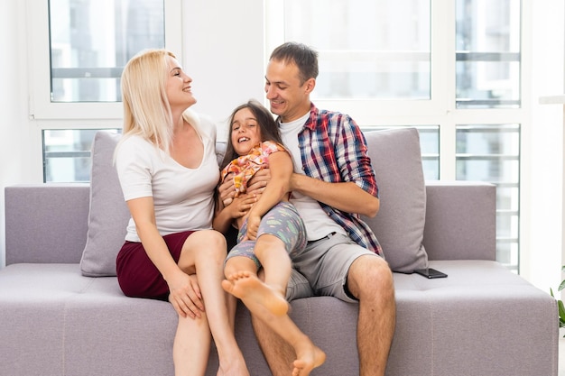 Sorrindo jovens pais e seu filho estão muito felizes, eles estão em casa