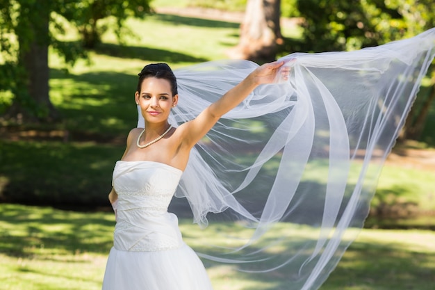 Sorrindo linda noiva de pé no parque